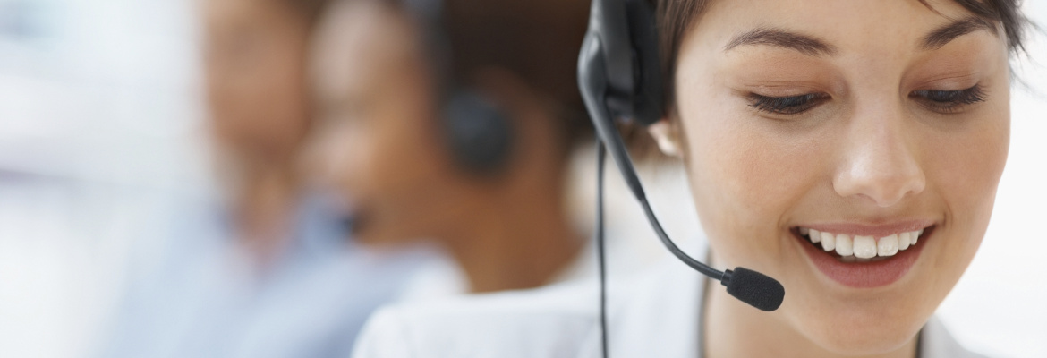 Beautiful customer representative with headset smiling during a telephone conversation